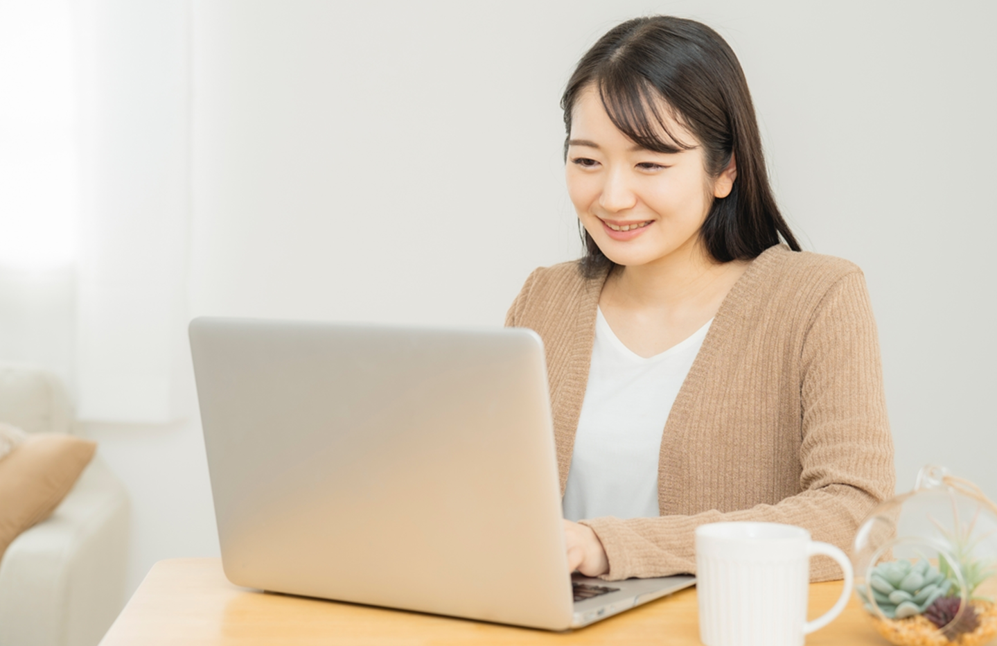 笑顔でパソコンを開く女性